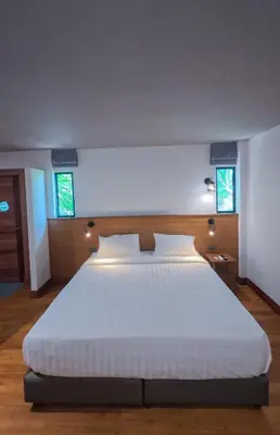a bedroom with a large white bed with two windows at Salty Pearl Phuket 2 in Patong Beach