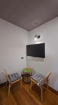 a room with two chairs and a table and a flat screen tv at Salty Pearl Phuket 2 in Patong Beach