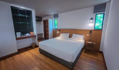 a bedroom with a white bed and two windows at Salty Pearl Phuket 2 in Patong Beach