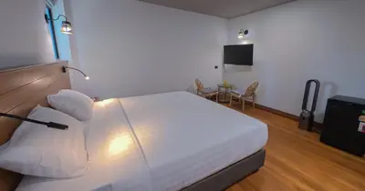 a hotel room with a bed and a television at Salty Pearl Phuket 2 in Patong Beach