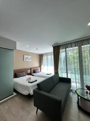 a hotel room with two beds and a couch at Condominium Royal Lee Airport Phuket30 in Ban Bo Han