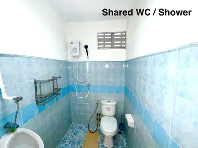 a blue tiled bathroom with a toilet and a shower at Patong Canal Villa 313 in Patong Beach