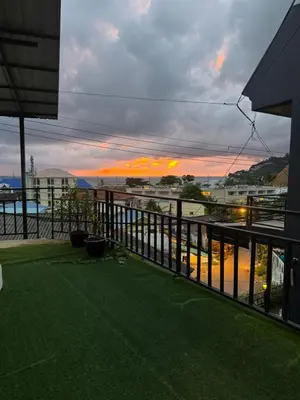 a balcony with a view of the ocean at sunset at Rinda House Patong 31 in Patong Beach