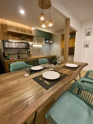 a large wooden table with chairs in a kitchen at Rinda House Patong 31 in Patong Beach