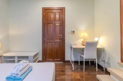 a room with a bed and a desk and a door at V241 3BR Peaceful Pool Villa, Garden & Jacuzzi in Koh Lone