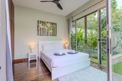 a bedroom with a white bed and sliding glass doors at V241 3BR Peaceful Pool Villa, Garden & Jacuzzi in Koh Lone