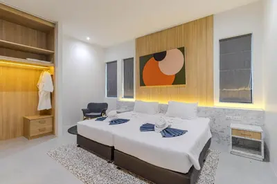 a bedroom with a large white bed and a chair at V242 Prime Location 2BR with Pool&Garden Near Beach in Bang Tao Beach