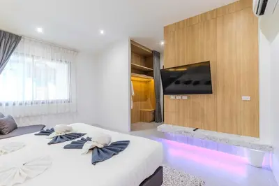 a bedroom with two beds and a tv on a wall at V243 Quite 3BR Pool Villa Bathtub Near Beach in Bang Tao Beach
