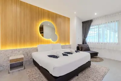 a bedroom with a large bed and a chair at V243 Quite 3BR Pool Villa Bathtub Near Beach in Bang Tao Beach