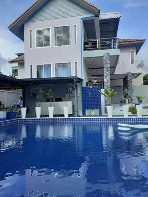 a house with a swimming pool in front of a house at Villa Rawai Pool 3 Room in Ban Saiyuan (1)