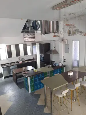 a kitchen with tables and chairs in a kitchen at Villa Rawai Pool 3 Room in Ban Saiyuan (1)