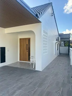 a white house with a patio with a wooden door at House No 21-77 Near bangtao beach Phuket in Koh Lone