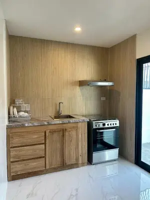 a kitchen with wooden cabinets and a stainless steel oven at House No 21-77 Near bangtao beach Phuket in Koh Lone