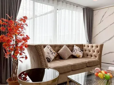 a living room with a couch and a glass table at Modern House in Phuket Town in Ban Na Khua