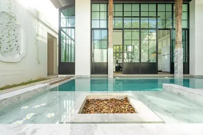 a building with a pool with rocks in it at MONO Villa Bang Tao 3 bedroom modern pool villa in Ban Pak Lak