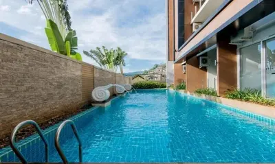 a swimming pool in front of a building at A Big Condo in Karon Walking distance to Beach in Karon Beach