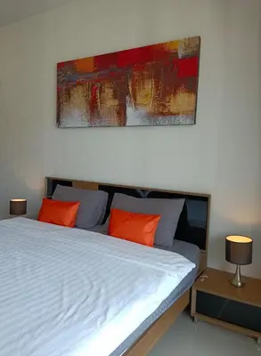 a bedroom with a bed with two orange pillows at A Big Condo in Karon Walking distance to Beach in Karon Beach