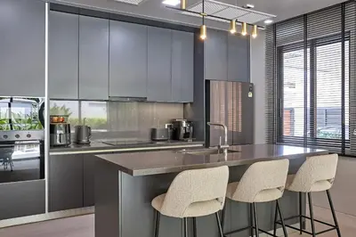 a kitchen with a counter and stools in it at Villa Botanica Modern Loft 2 in Ban Tha Rua