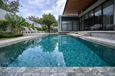 a swimming pool in front of a house at Villa Botanica Modern Loft 2 in Ban Tha Rua