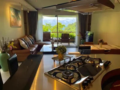 a kitchen with a stove top oven in a living room at Kata Eden View - 1 BR Beachfront Luxury Apartment in Karon Beach