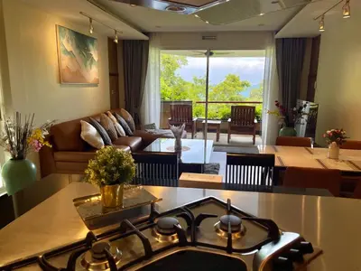 a kitchen and living room with a stove top at Kata Eden View - 1 BR Beachfront Luxury Apartment in Karon Beach