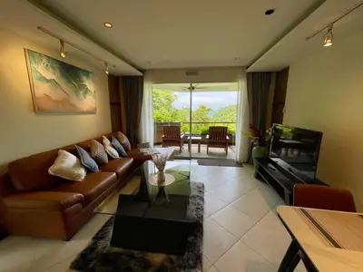a living room with a couch and a table at Kata Eden View - 1 BR Beachfront Luxury Apartment in Karon Beach