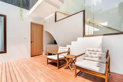 a room with two chairs and a table and a staircase at Qabalah by Villacarte in Ban Pak Lak
