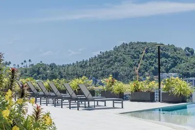 a row of lounge chairs next to a swimming pool at Beautiful Andamaya sea view in Ban Thalat Choeng Thale