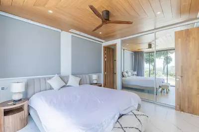 a bedroom with a bed with a ceiling fan at Beautiful Andamaya sea view in Ban Thalat Choeng Thale
