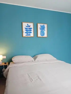 a white bed with two pictures on a blue wall at Stylish Urban Escape 1Bed Apt T2-822 in Chalong