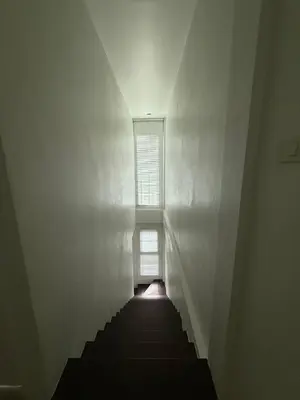a staircase leading to a window in a white room at Town House European Style in Ban Ket Ho