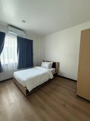 a bedroom with a bed and a large window at Town House European Style in Ban Ket Ho