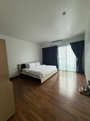 a bedroom with a bed and a wooden floor at Town House European Style in Ban Ket Ho