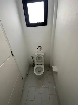 a small bathroom with a toilet with a window at Town House European Style in Ban Ket Ho