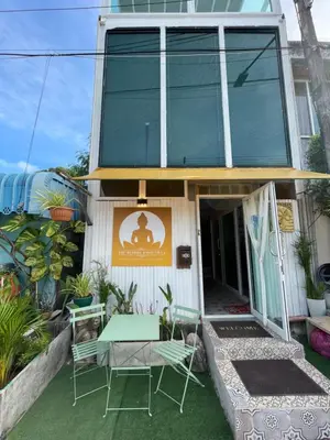 a house with a green table and chairs in front of it at The Buddha Rawai Villa in Ban Saiyuan (1)