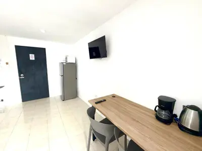 a kitchen with a wooden table and a refrigerator at Patong Canal Villa 302 in Patong Beach