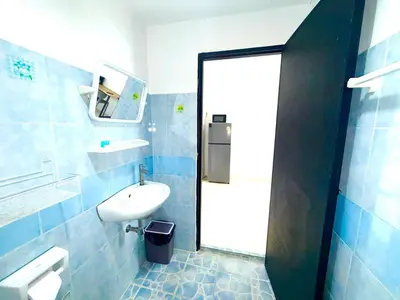 a blue tiled bathroom with a sink and a mirror at Patong Canal Villa 302 in Patong Beach