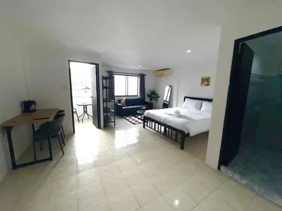 a bedroom with a bed and a desk and a table at Patong Canal Villa 302 in Patong Beach