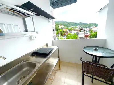 a kitchen with a sink and a table and a window at Patong Canal Villa 302 in Patong Beach