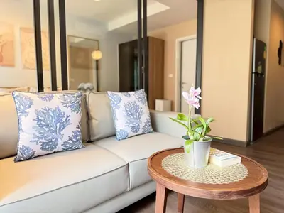 a living room with a white couch and a table at The Deck Patong Phuket by Mickey in Patong Beach