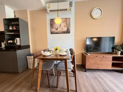 a living room with a table and a tv at The Deck Patong Phuket by Mickey in Patong Beach