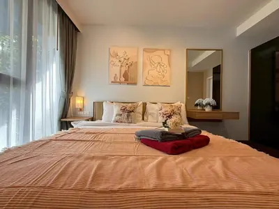 a bedroom with a large bed with a orange blanket at The Deck Patong Phuket by Mickey in Patong Beach