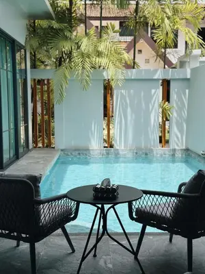 a table and two chairs in front of a swimming pool at Exclusive 2BR Pool Villa in Ban Saiyuan (1)