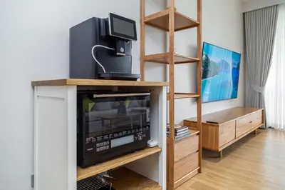 a living room with a tv on a shelf at Beachside 2 bedrooms apartment 200 meters to Bang Tao Beach Manage by OCEAN HUB in Bang Tao Beach