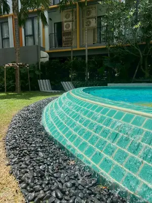 a swimming pool with two chairs in front of a house at The Base Rise Central Phuket in Ban Rangeng