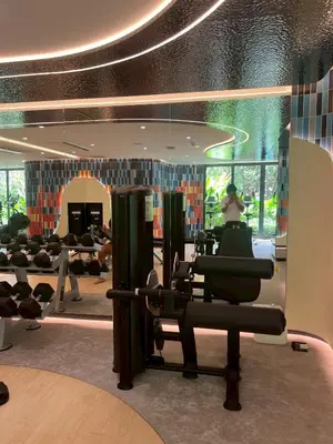 a gym with chairs and a woman in the background at The Base Rise Central Phuket in Ban Rangeng