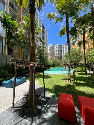 a resort with a palm tree and a playground at The Base Rise Central Phuket in Ban Rangeng