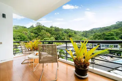 a balcony with a view of a river and mountains at Hillside 2BR Apartment with Pool & Gym 5 Min to Kamala Beach 48RK in Kamala Beach