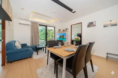 a dining room and living room with a table and chairs at Hillside 2BR Apartment with Pool & Gym 5 Min to Kamala Beach 48RK in Kamala Beach