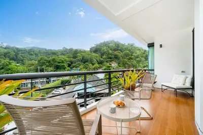 a balcony with a table and chairs and a view at Hillside 2BR Apartment with Pool & Gym 5 Min to Kamala Beach 48RK in Kamala Beach